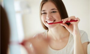 The woman brushes her teeth twice a day.